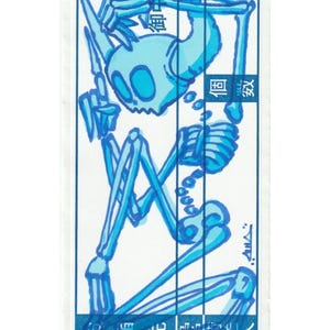 May include: A blue and white sticker featuring a cartoon skeleton illustration. The skeleton is in a seated position with its arms raised. Japanese text is visible at the top and bottom of the sticker.