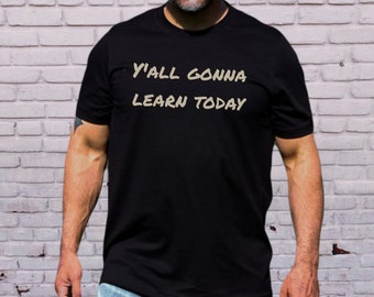 Puede incluir: Una camiseta negra con el texto "Y'all gonna learn today" impreso en beige.