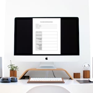 以下が含まれることがあります： 「ビジネスを始める前に考慮すべき10のこと」というタイトルの文書が表示されたコンピューター画面。文書は、見出しとメモ用の空白のあるセクションに分かれています。コンピューターは木製スタンドの上にあり、その前にキーボードがあります。