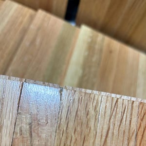 Puede incluir: Primer plano de un suelo de madera de color marr&oacute;n claro. Las tablas de madera est&aacute;n dispuestas en un patr&oacute;n horizontal y tienen una veta natural.
