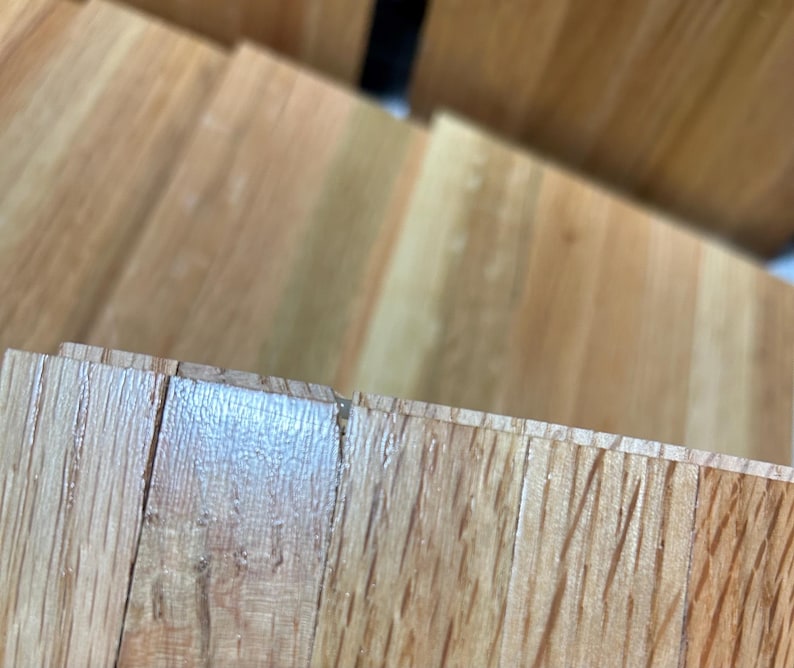 Puede incluir: Primer plano de un suelo de madera de color marr&oacute;n claro. Las tablas de madera est&aacute;n dispuestas en un patr&oacute;n horizontal y tienen una veta natural.
