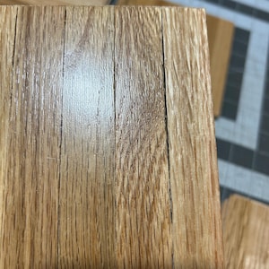 Puede incluir: Primer plano de una superficie de madera con un patr&oacute;n de veta de madera natural. La madera es de color marr&oacute;n claro y tiene un acabado liso y pulido.