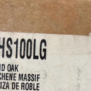 Puede incluir: Primer plano de una etiqueta blanca con texto negro. La etiqueta dice "AHS100LG" y "SOLID OAK DE CHENE MASSIF MACIZA DE ROBLE".