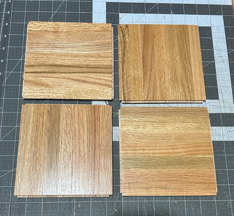 Puede incluir: Cuatro piezas cuadradas de suelo de madera en color marr&oacute;n claro con un patr&oacute;n de veta de madera. Las tablas de madera est&aacute;n dispuestas en forma de cuadr&iacute;cula.