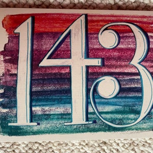 May include: A white painted number "143" on a background of colorful watercolor stripes in shades of red, purple, blue, and green.