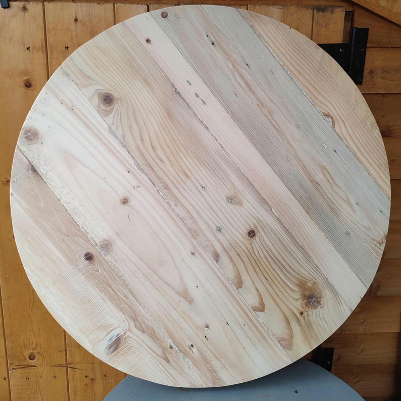 Op de afbeelding: Een ronde houten tafelblad gemaakt van gerecycled hout. Het hout heeft een natuurlijke lichtbruine kleur met een licht verweerde uitstraling.