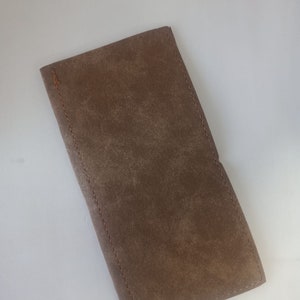 May include: A brown leather wallet with a stitched edge.