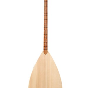 May include: A light-colored, pear-shaped stringed instrument, likely a saz or similar folk instrument. The body is made of light wood, with a long neck and tuning pegs at the top. The instrument is designed for playing music.