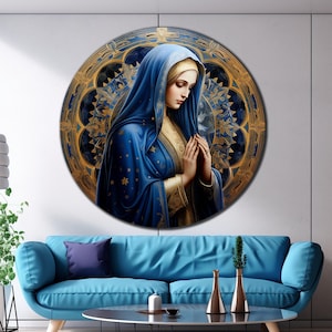 May include: A round canvas print featuring a painting of a woman in a blue robe with a gold halo, praying with her hands clasped. The background is a gold and blue mandala design.