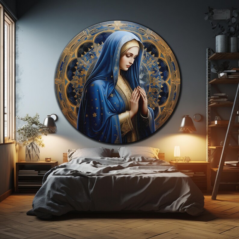May include: A round painting of a woman in a blue robe with a gold trim, praying with her hands clasped together. The background is a blue and gold mandala pattern.