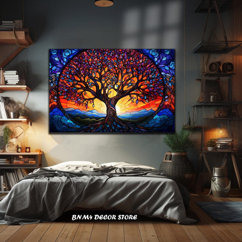 May include: A colorful stained glass style painting of a tree with a sunset in the background. The tree has a thick trunk and many branches with leaves in shades of purple, red, and orange. The sunset is a vibrant orange and yellow with a blue sky above. The painting is framed and hanging on a wall in a bedroom.