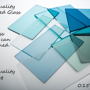 May include: A close-up of several pieces of tempered glass in various shades of blue and green. The glass is 0.15 inches (4 mm) thick and has a smooth, cleanable surface. The text "High Quality Tempered Glass" is written at the top of the image. The text "The glass surface can be cleaned." is written on the left side of the image. The text "High quality printing" is written at the bottom left of the image.