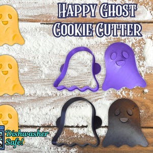 May include: Image features a "Happy Ghost Cookie Cutter" with three yellow ghost cookies and three ghost-shaped cookie cutters in purple and black. The text "Dishwasher Safe!" is also visible.