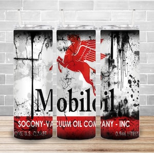 May include: A white tumbler with a black and white distressed background featuring a red winged horse and the text "Mobil Oil Socony-Vacuum Oil Company - Inc. One U.S. Quart 0.946 Litres".