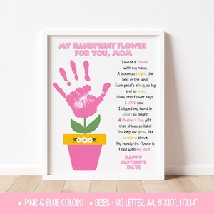 May include: A framed print with a pink handprint flower design. The text reads "My Handprint Flower For You, Mom" and includes a poem about a Mother's Day gift. The print is in a white frame.