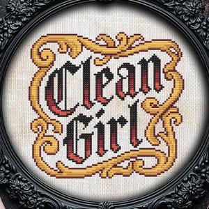 Könnte beinhalten: Ein gerahmtes Kreuzstichdesign mit den Worten "Clean Girl" in einer gotischen Schrift. Der Text ist in Rot und Schwarz gehalten und wird von einem goldenen und gelben, verzierten Rahmen umgeben. Der schwarze Rahmen hat ein aufwendiges Vintage-Design.