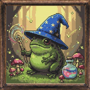 May include: A framed cross-stitch art piece featuring a green frog wizard wearing a blue hat with stars. The frog holds a wand, surrounded by mushrooms and a potion bottle. The background depicts a forest scene.