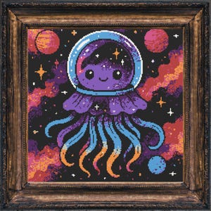 May include: A framed cross-stitch art piece featuring a cartoon jellyfish in an astronaut helmet. The jellyfish is purple with blue and orange tentacles, set against a black space background with planets and stars. The frame is a dark wood.