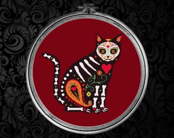 May include: A black cat with a sugar skull design, sitting on a red background. The cat has white bones, a red heart, and colorful flowers.