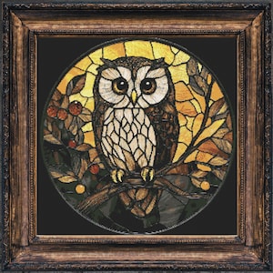 May include: A stained glass owl with brown and white feathers, perched on a branch with yellow and orange leaves. The owl is set against a dark background and framed in a dark wood frame.