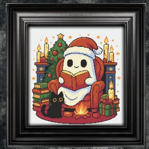 May include: A framed cross-stitch design featuring a ghost wearing a Santa hat, reading a book in a cozy armchair. A black cat sits nearby. The scene includes a Christmas tree, candles, gifts, and a small fire, creating a festive holiday atmosphere.