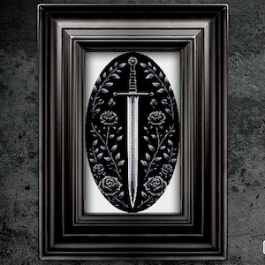 Może przedstawiać: Wzór haftu krzyżykowego w czerni i bieli przedstawiający miecz otoczony różami w owalnej ramie.
