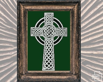Puede incluir: Una cruz celta blanca con un intrincado diseño de nudos sobre un fondo verde. La cruz está enmarcada en un marco de madera marrón oscuro.