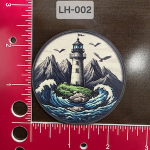 Peut inclure: Autocollant rond représentant un phare sur une île rocheuse, entouré de vagues déferlantes et de montagnes. Le design comprend des oiseaux en vol et le texte "LH-002". La palette de couleurs comprend des nuances de bleu, vert, blanc et gris.