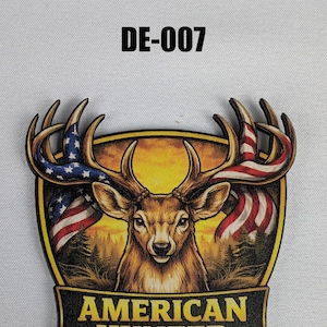 May include: A wooden emblem featuring a deer with antlers adorned with the American flag. The emblem has a yellow border and the text "AMERICAN HUNTER" at the bottom. The code "DE-007" is at the top.
