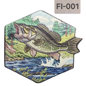 Puede incluir: Un parche de forma hexagonal con una ilustración detallada de una lubina de boca grande saltando fuera del agua. La lubina es verde, marrón y negra con la barriga blanca. El agua es azul y verde con espuma blanca. El fondo es un bosque verde con árboles y arbustos. El parche tiene un borde blanco y el texto "FI-001" en la esquina superior derecha.