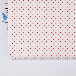 May include: White fabric with a red polka dot pattern.