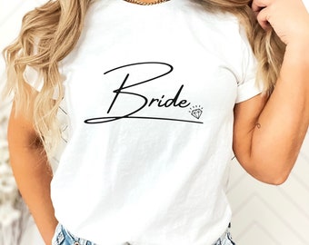 Puede incluir: Camiseta blanca con la palabra "Bride" escrita en cursiva con un símbolo de diamante al lado.