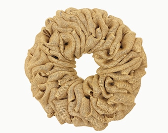 May include: A brown burlap wreath with a natural, rustic look. The wreath is made of tightly woven burlap and has a circular shape.