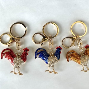 Llavero con diseño de gallo, colgante para bolso naranja, azul y rojo, tirador de cremallera para mochila, colgador de bolso con diamantes de imitación, decoración de diseñador, pájaro adorable, colgante con diseño de pollito.