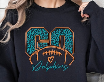 May include: Black sweatshirt with a teal and orange graphic of a football with the words "Go Dolphins" and a heart.