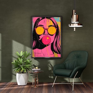 May include: Pop art style framed print of a woman blowing a bubblegum bubble. The woman wears yellow sunglasses and has long black hair. The background is a mix of pink, yellow, and blue.