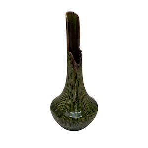 May include: A green ceramic vase with a textured, vertical-line pattern. The vase has a bulbous base and a tall, open top with a dark brown interior. The vase is approximately 10 inches tall.