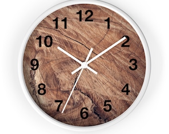 May include: A white round clock with black numbers and white hands. The clock face is a wood grain pattern with cracks.