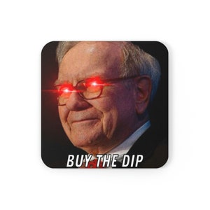 Könnte beinhalten: Nahaufnahme eines Mannes mit roten Laseraugen, der eine Brille und einen Anzug trägt. Der Text "BUY THE DIP" befindet sich unter dem Bild.