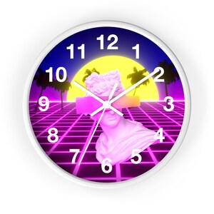 Pode incluir: Um relógio de parede branco com um design retro dos anos 80. O mostrador do relógio apresenta um padrão de grade rosa e roxo, um sol amarelo, palmeiras e um busto branco de uma pessoa com uma faixa rosa e amarela sobre os olhos. Os números do relógio são pretos.