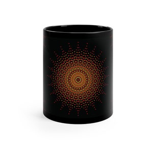May include: Black ceramic mug with a red, yellow, and orange mandala design.
