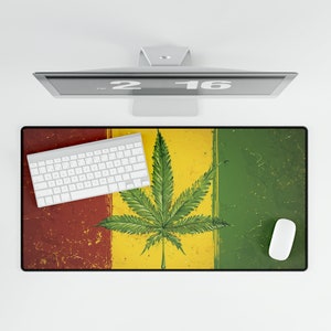 Puede incluir: Una alfombrilla de escritorio roja, amarilla y verde con un diseño de hoja de marihuana. La alfombrilla está hecha de un material duradero y es perfecta para proteger tu escritorio de arañazos y derrames.