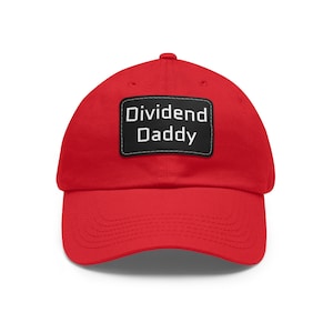 Puede incluir: Gorra de béisbol roja brillante con visera curva. Un parche rectangular negro en la parte delantera muestra las palabras "Dividend Daddy" en letras blancas. La gorra está hecha de tela suave y tiene un estilo clásico e informal.