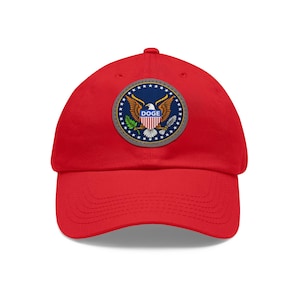 May include: A red baseball cap featuring a circular patch with a blue background, gold eagle, and the word "DOGE". The patch is surrounded by a ring of white stars. The cap is made of a soft material and has a curved brim.