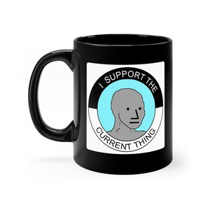 May include: Black ceramic mug with a white circle containing a gray cartoon face and the text "I support the current thing".