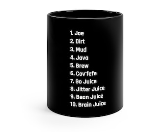 May include: Black ceramic coffee mug with white text listing coffee-related terms: Joe, Dirt, Mud, Java, Brew, Cov'fefe, Go Juice, Jitter Juice, Bean Juice, and Brain Juice. The mug is cylindrical and has a glossy finish.