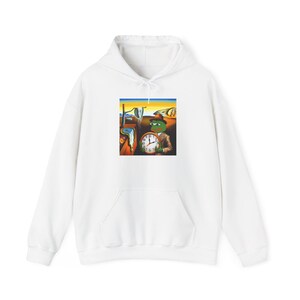 Könnte beinhalten: Weißer Kapuzenpullover mit einem Grafikdruck eines grünen Frosches, der eine Uhr vor einem Gemälde hält. Das Gemälde ist eine Nachbildung von Salvador Dalis "Die Beständigkeit der Erinnerung".