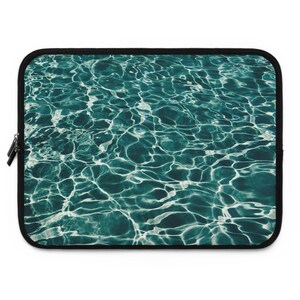 May include: A laptop sleeve with a teal blue and white abstract pattern of rippling water.