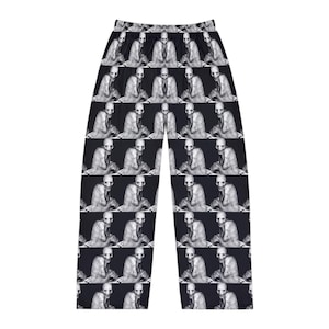 May include: Black and white patterned pajama pants featuring a repeated image of a person's face.