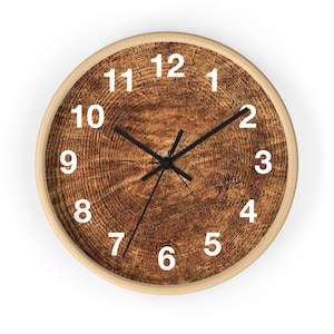 May include: A round wooden clock with a brown wood grain pattern and white numbers. The clock face has black hands and a white border.